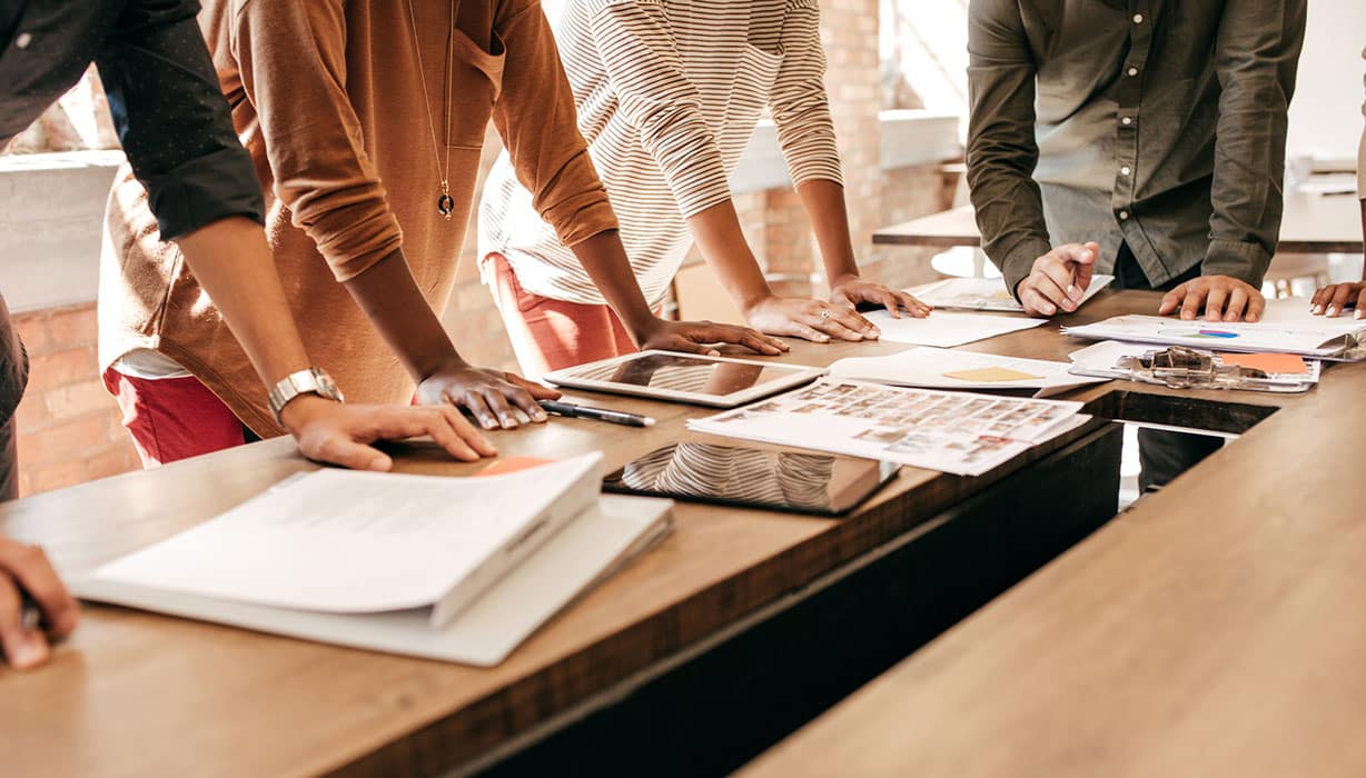 several people leaning on a table
